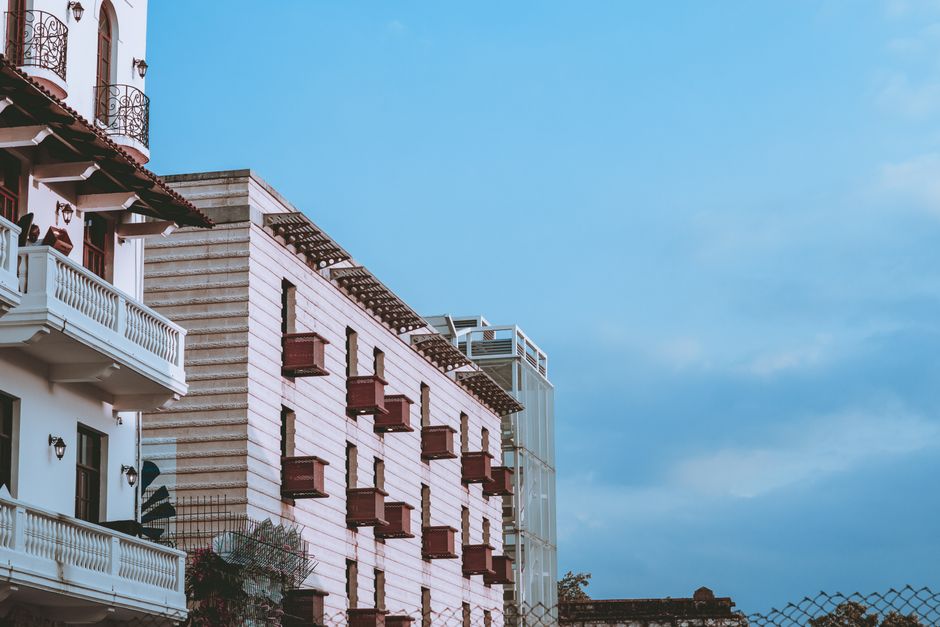 Low-angle view of an elegant building with balconies against a clear blue sky, perfect for architectural themes.