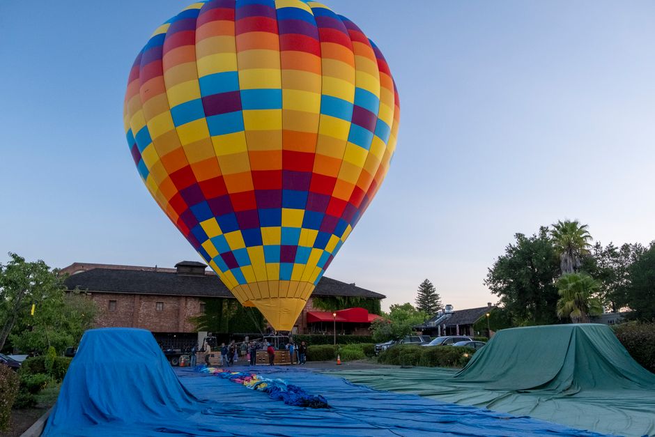 Vibrant hot air balloon ready to take off at sunrise in Napa, California.