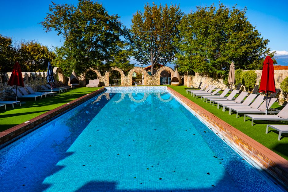 Inviting outdoor swimming pool surrounded by lounge chairs in sunny Telavi, Georgia.