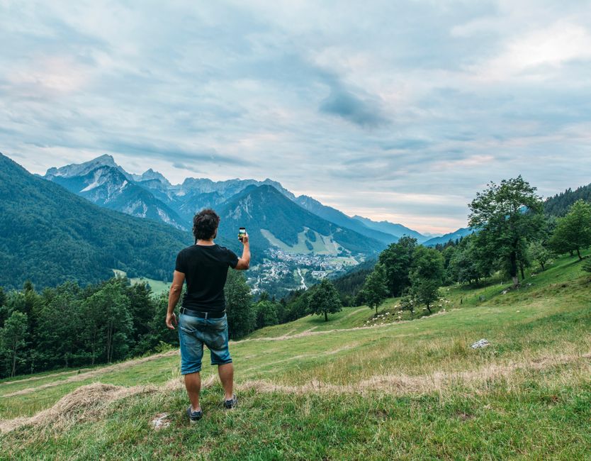 A person admires the beautiful mountain scenery in Jesenice, Slovenia, capturing nature's beauty.