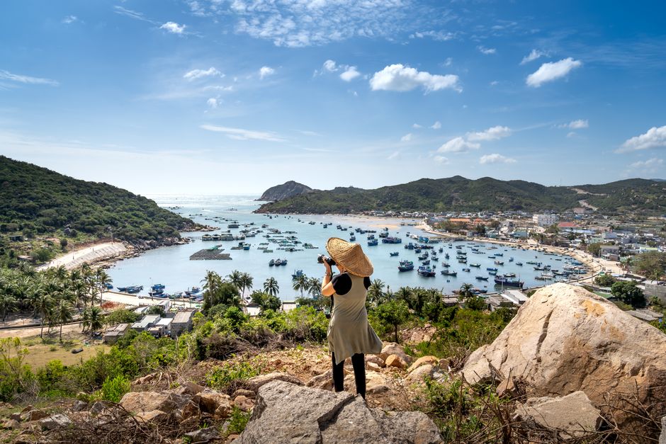 A picturesque view of Vinh Hy Bay in Vietnam with boats and lush hills, captured by a traveler.