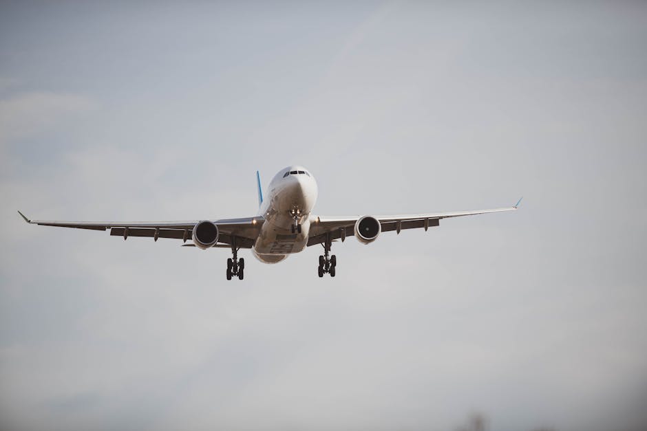 Large commercial airplane flying through a cloudy sky, captured from below mid-flight.