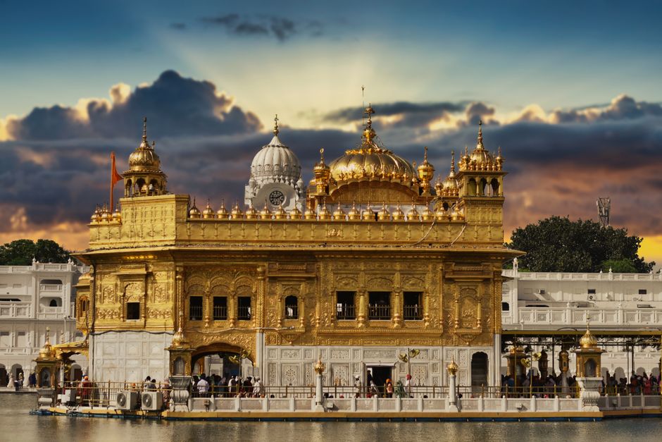 Stunning view of the Golden Temple in Amritsar, India, with a vibrant sunset sky.