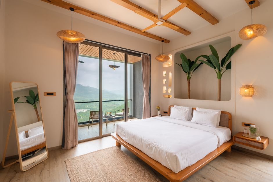Elegant bedroom with modern decor and a stunning mountain vista through large glass doors.
