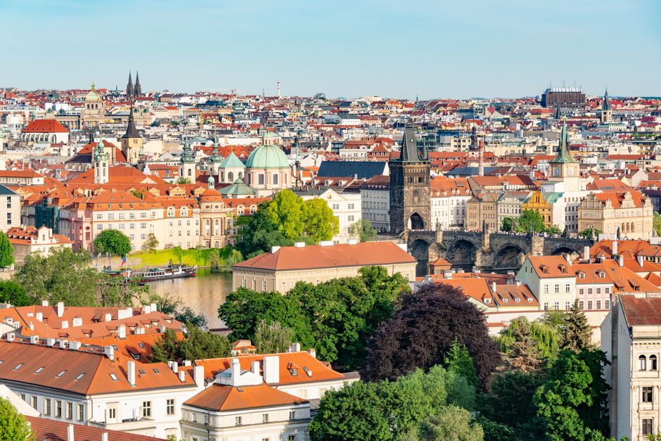 A stunning view of Prague's historical architecture and Charles Bridge across Vltava River.