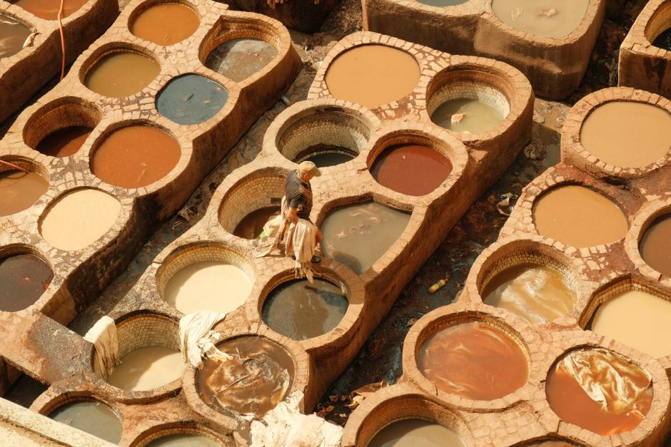 Overhead view of a traditional leather tannery in Fes with various color dye pits.