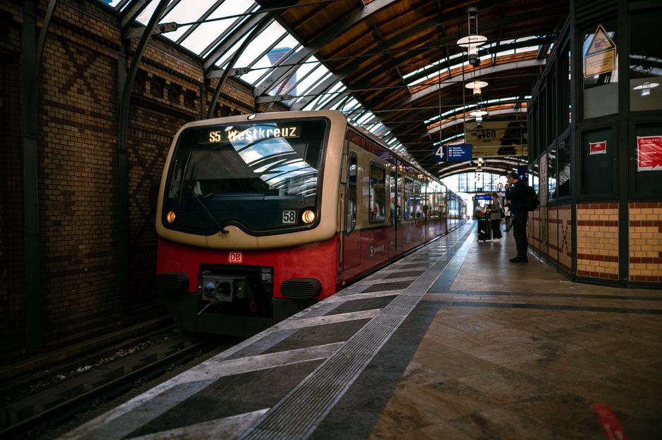 A sleek train arriving at a bustling Berlin station, capturing city life and travel