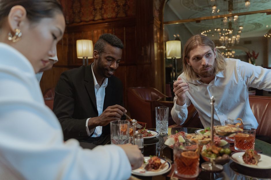 A stylish group enjoying a delicious meal in a sophisticated restaurant setting.