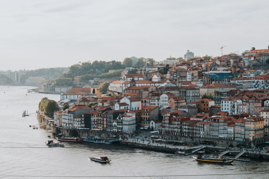 Explore a picturesque view of Porto's historic waterfront with colorful buildings and serene riverscape.