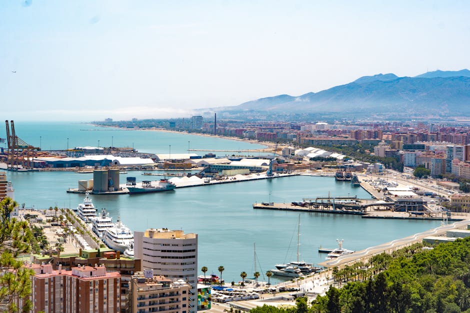 Aerial view of Málaga's bustling port and cityscape set against a mountainous backdrop.